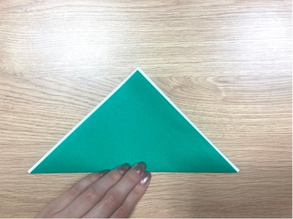 2. 少しずらして下から三角形を折るように谷折りします